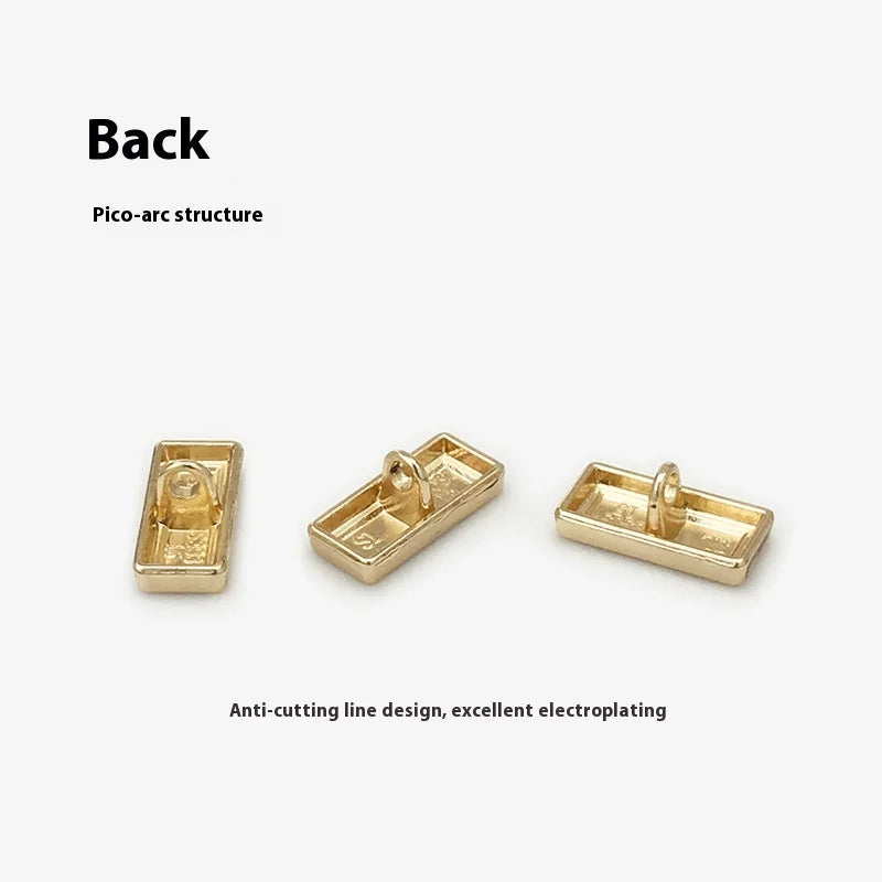 Оддий костюм ва пальто тугмаси — экологик тоза, металл тусли олтин рангдаги тўртбурчак шаклли декоратив тугма. Кийим учун аксессуар сифатида ишлатилади. Платировка (юза қопламаси) билан ясалган